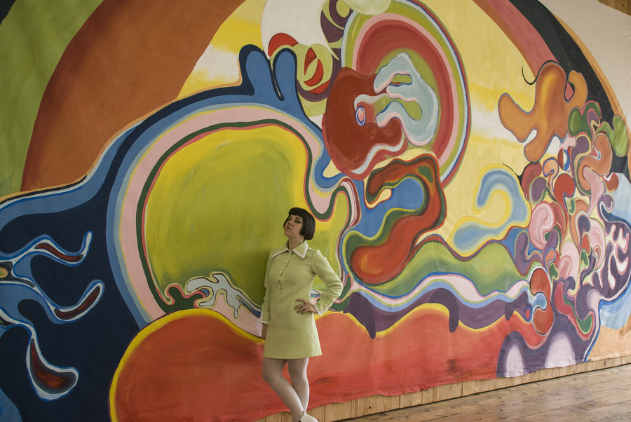 Instalación site-specific de Ornella Ruiz Díaz: pintura mural de gran formato sobre tela, con la artista frente a la obra