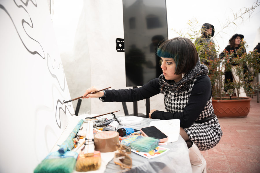 Ornella Ruiz Díaz pintando en vivo sobre un muro en Casapueblo, Uruguay